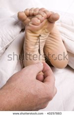 stock-photo-a-man-s-hand-tickling-a-woman-s-feet-with-a-feather-while-her-feet-are-poking-out-of.jpg