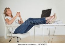 stock-photo-casual-businesswoman-having-a-coffee-with-her-feet-up-at-desk-in-her-office-18740483.jpg