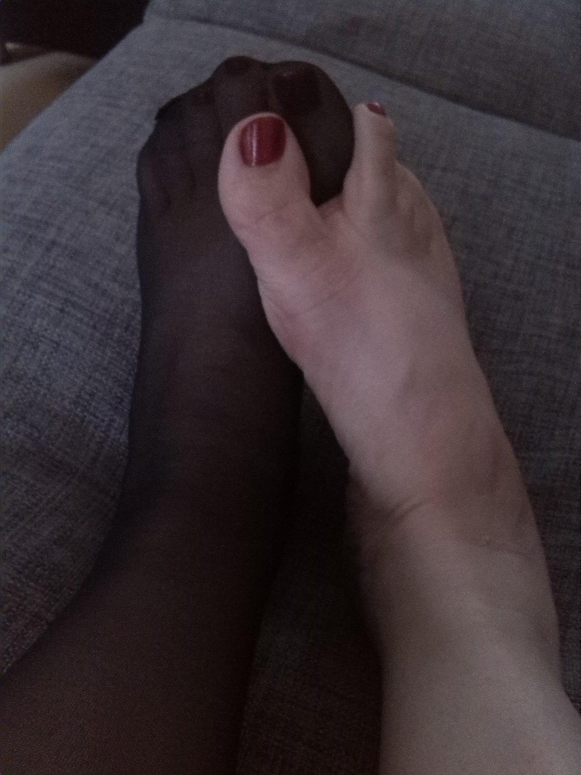One foot in nylon and one bare with deep red shimmery polish