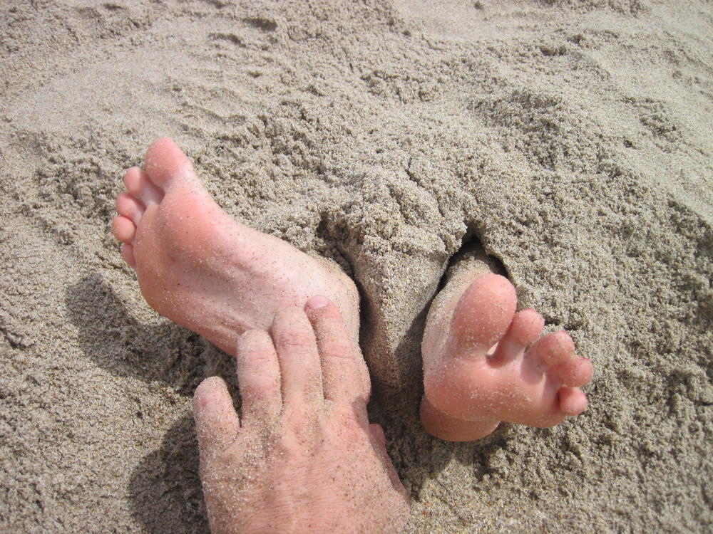 Tickling her in the sand..